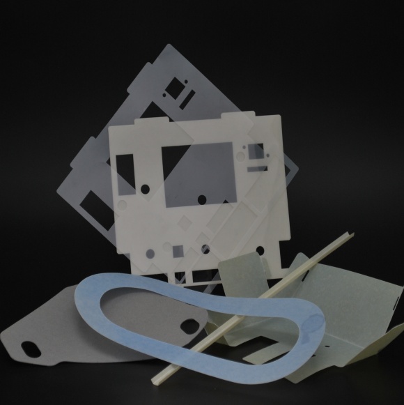 Die-cut flat parts in white, gray and beige with cut-out openings, plus a light blue oval ring