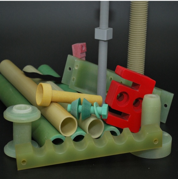 Machined parts in light green, beige, red and turquoise: tubes, threaded rods, plates and a drilled strip