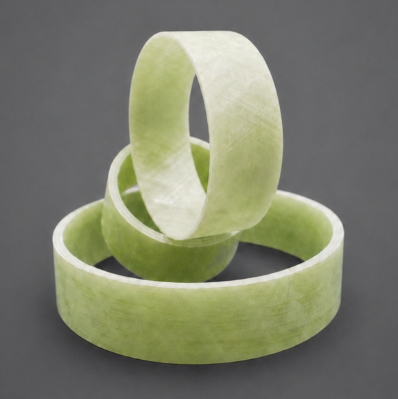 Three wound rings and tube sections in light green glass-fibre composite