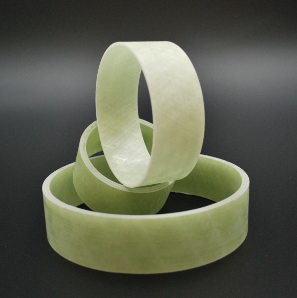 Three wound rings and tube sections in light green glass-fibre composite