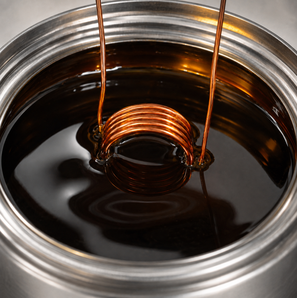 Copper coil being dipped into dark impregnating resin