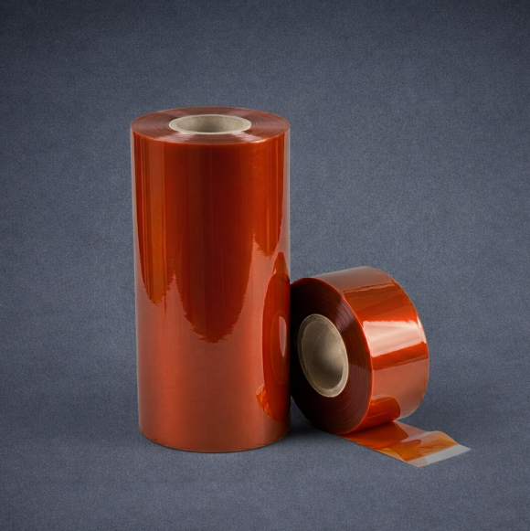 Two rolls of orange coated film, one standing and one lying