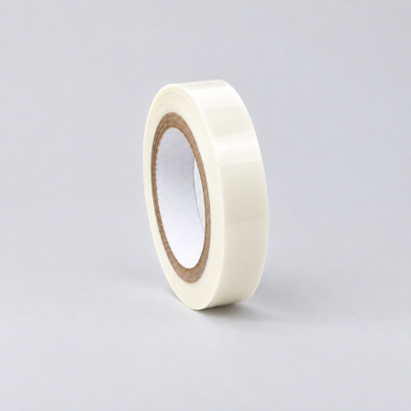 Milky translucent tape roll with a cardboard core, standing upright on a light grey background.