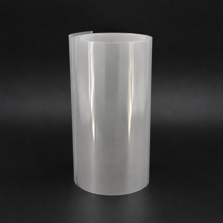 A tall, upright roll of glossy, translucent white PEN film with a visible open core and a slightly raised outer edge, photographed against a dark charcoal background.